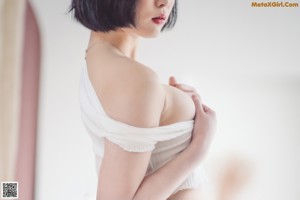 A woman in a white top is posing for a picture.