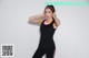 A woman in a black tank top and black leggings posing for a picture.