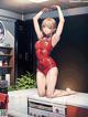 A woman in a red bathing suit sitting on top of a counter.