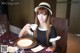 A woman sitting at a table with a cup of coffee.